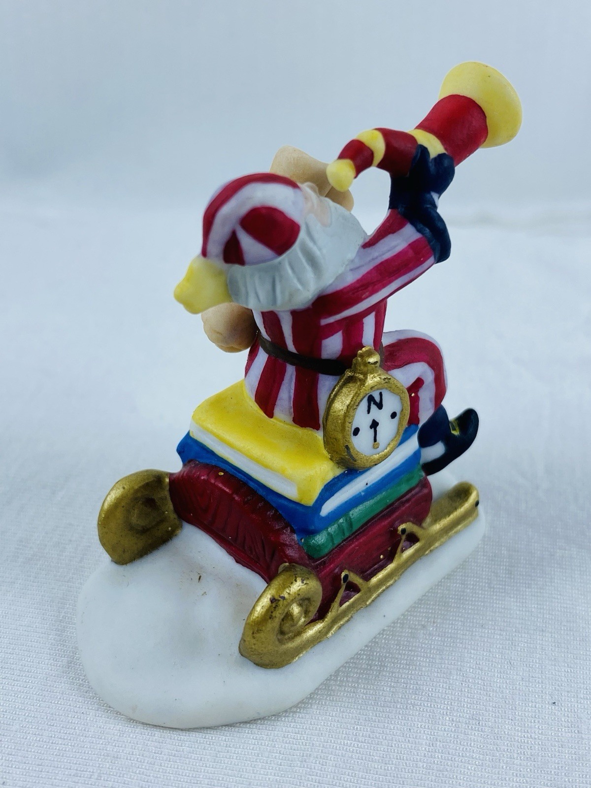 Department 56 H.V. Series Santa Claus In Red & White Striped Pajamas On A Sled