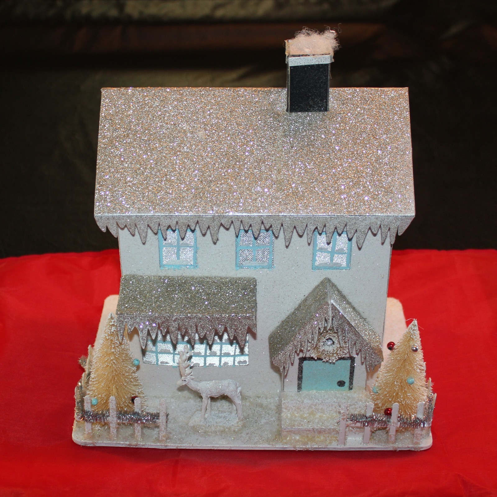 Putz Style Glitter House with Bottle Trees & Deer. LED Light. 10″ Tall